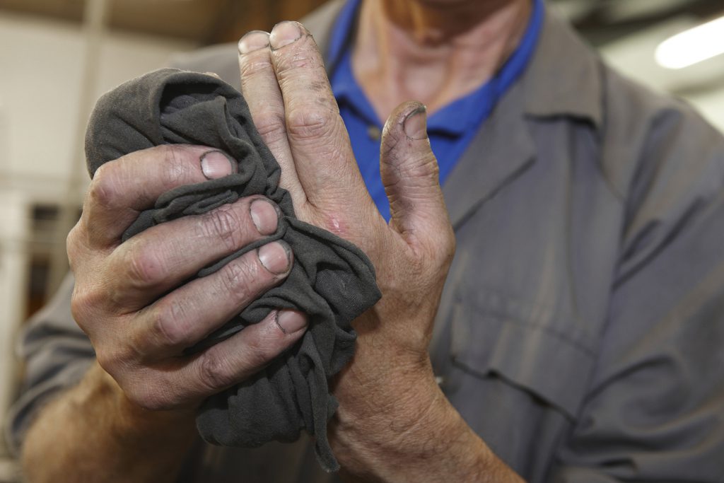 senior worker cleaning his hands with a cloth