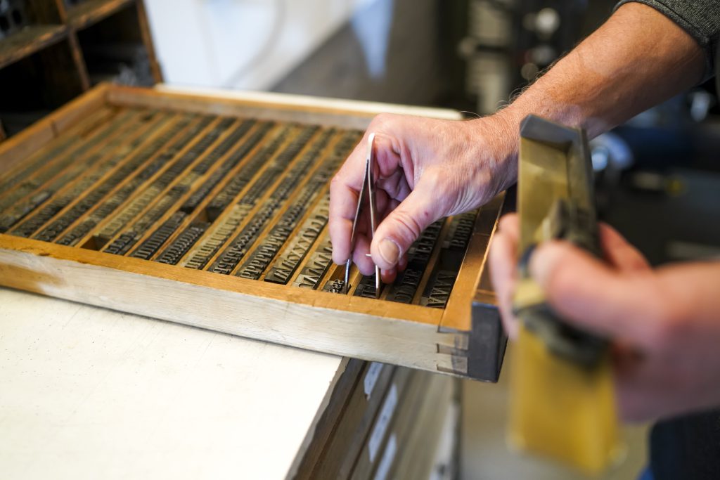 Buchdrucker Alfred Pfeifer beim Hantieren mit Bleilettern